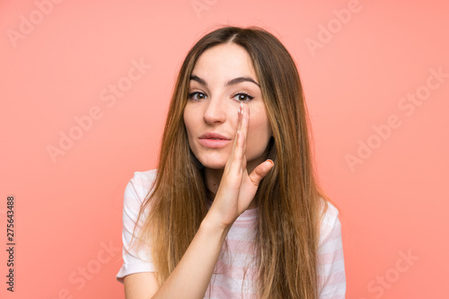 Young woman over isolated pink wall whispering something
