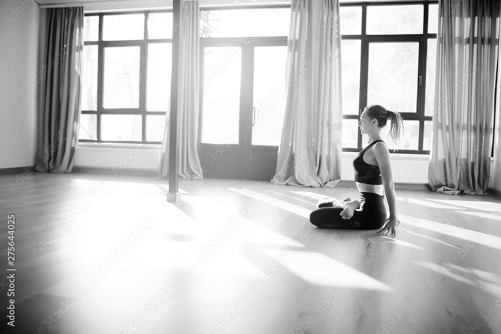 gymnasium, yoga classes / a girl engaged in yoga, a trom in a large gym, light and rays of the sun. concept of yoga for women gymnasium, yoga classes / a girl engaged in yoga, a trom in a large gym, light and rays of the sun. concept of yoga for women