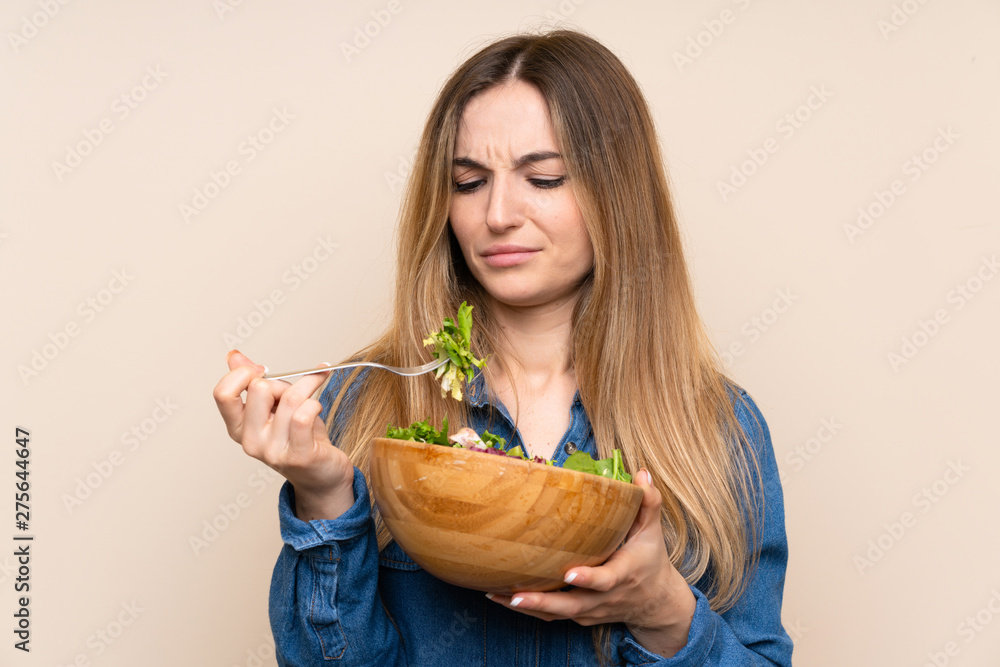 Young woman with salad over isolated background Young woman with salad over isolated background