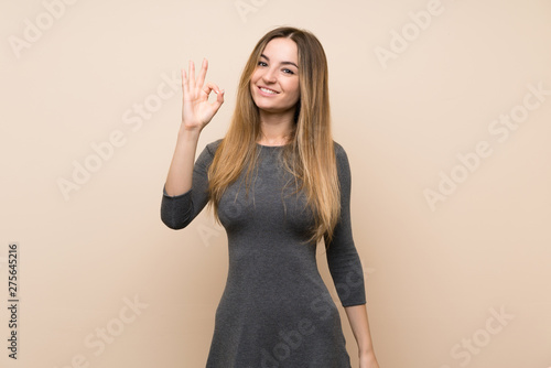 Young woman over isolated background showing ok sign with fingers