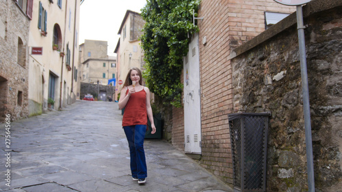 Young attractive woman walking on the streets and eat icecream of the historic town