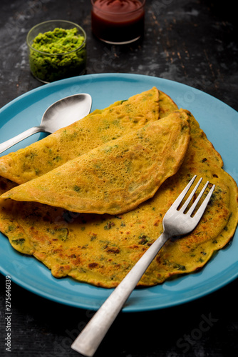 Chilla or Besan cheela is a simple pancake made with chickpea flour and some basic ingredients served with green chutney and tomato sauce, also known as veg-omelette photo