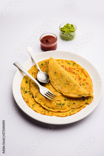 Chilla or Besan cheela is a simple pancake made with chickpea flour and some basic ingredients served with green chutney and tomato sauce, also known as veg-omelette photo