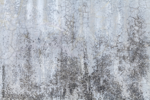 Old gray wall covered with uneven plaster. Texture of vintage shabby silver stone surface, closeup.