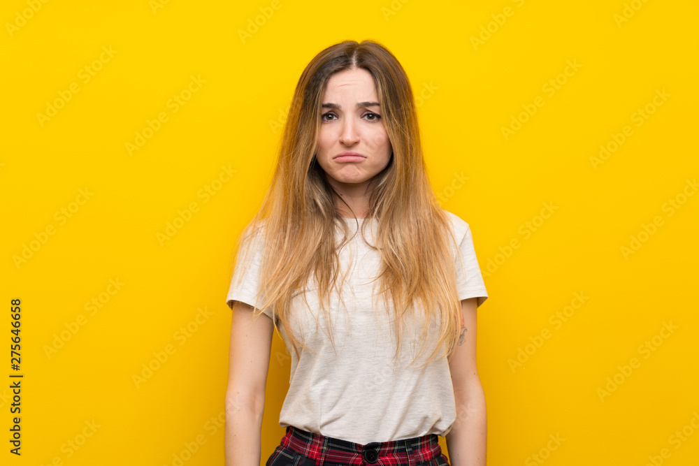 Young woman over isolated yellow wall sad Young woman over isolated yellow wall sad