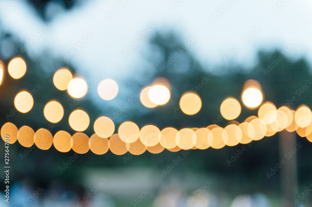 Light bulb decor in outdoor party. blurred photo - obrazy, fototapety, plakaty 