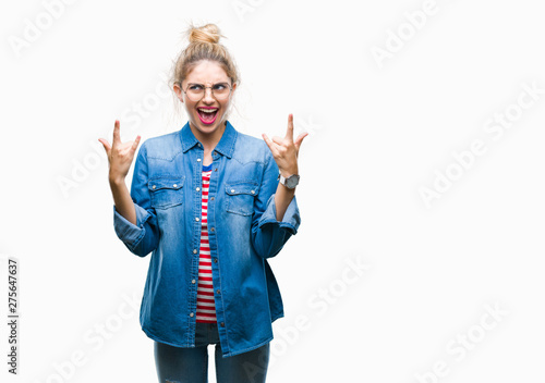 Young beautiful blonde woman wearing glasses over isolated background shouting with crazy expression doing rock symbol with hands up. Music star. Heavy concept.