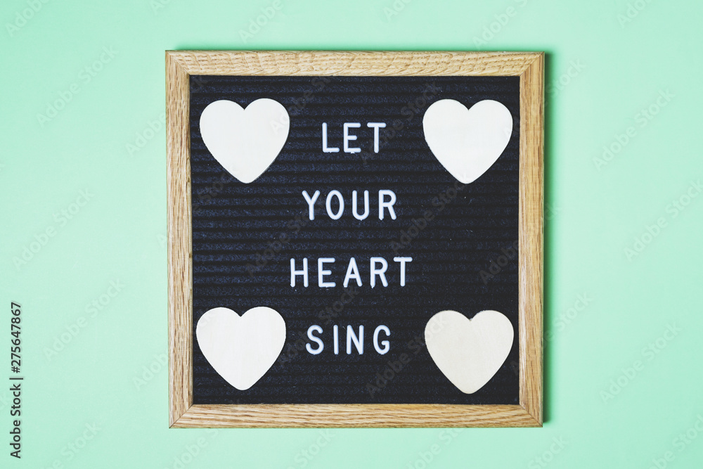 Decorated board with message and heart shape on turquoise backdrop Decorated board with message and heart shape on turquoise backdrop