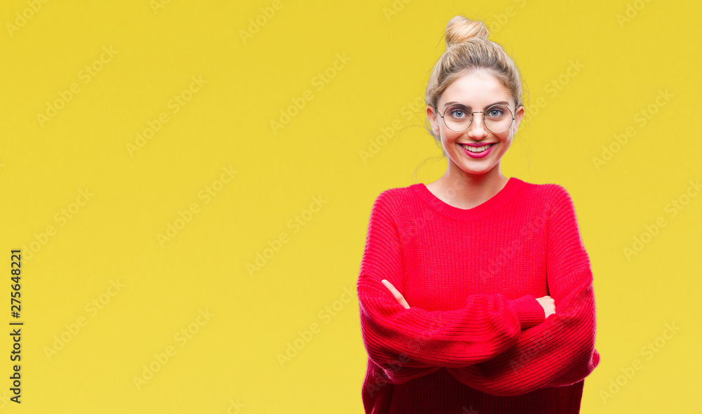Fototapeta premium Młoda piękna blondynka na sobie czerwony sweter i okulary na białym tle szczęśliwa buźka uśmiecha się ze skrzyżowanymi rękami patrząc w kamerę. Pozytywna osoba.