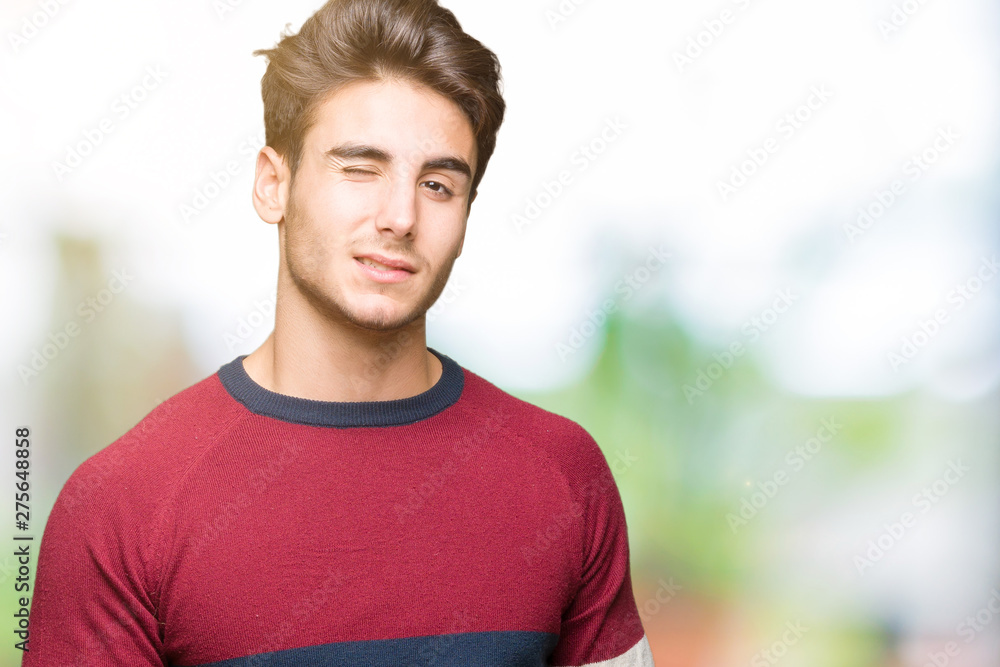 Young handsome man over isolated background winking looking at the camera with sexy expression, cheerful and happy face. Young handsome man over isolated background winking looking at the camera with sexy expression, cheerful and happy face.