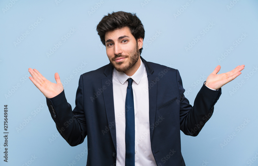 Businessman over isolated blue wall making doubts gesture Businessman over isolated blue wall making doubts gesture