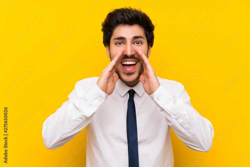 Businessman on isolated yellow background shouting with mouth wide open Businessman on isolated yellow background shouting with mouth wide open
