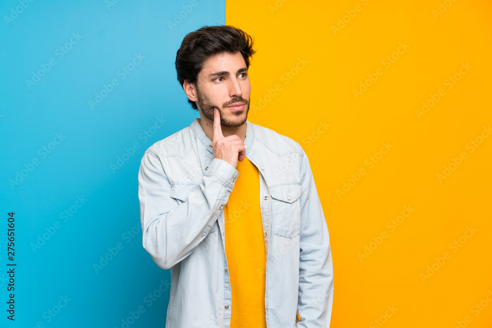 Handsome over isolated colorful background thinking an idea while looking up Handsome over isolated colorful background thinking an idea while looking up