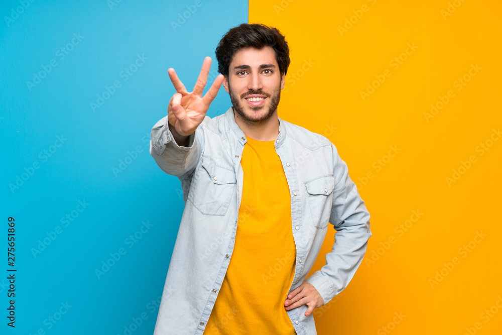 Handsome over isolated colorful background happy and counting three with fingers Handsome over isolated colorful background happy and counting three with fingers