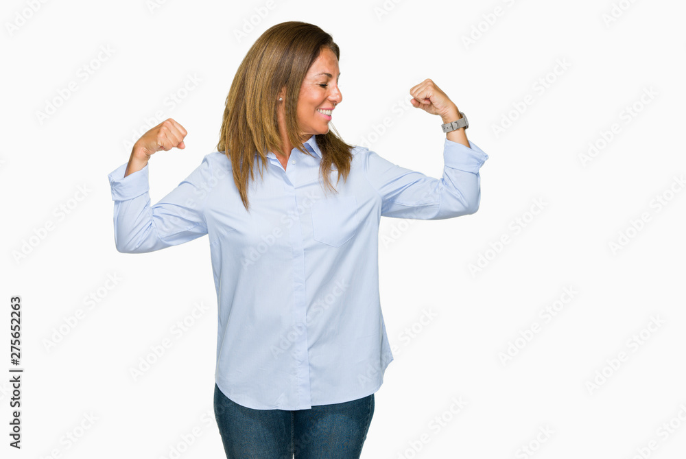 Obraz premium Beautiful middle age business adult woman over isolated background showing arms muscles smiling proud. Fitness concept.