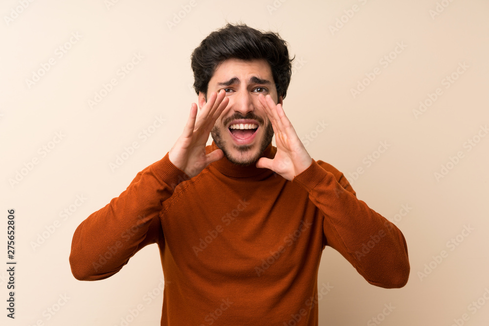 Handsome over isolated wall shouting with mouth wide open Handsome over isolated wall shouting with mouth wide open