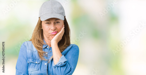 Beautiful middle age woman wearing sport cap over isolated background thinking looking tired and bored with depression problems with crossed arms.