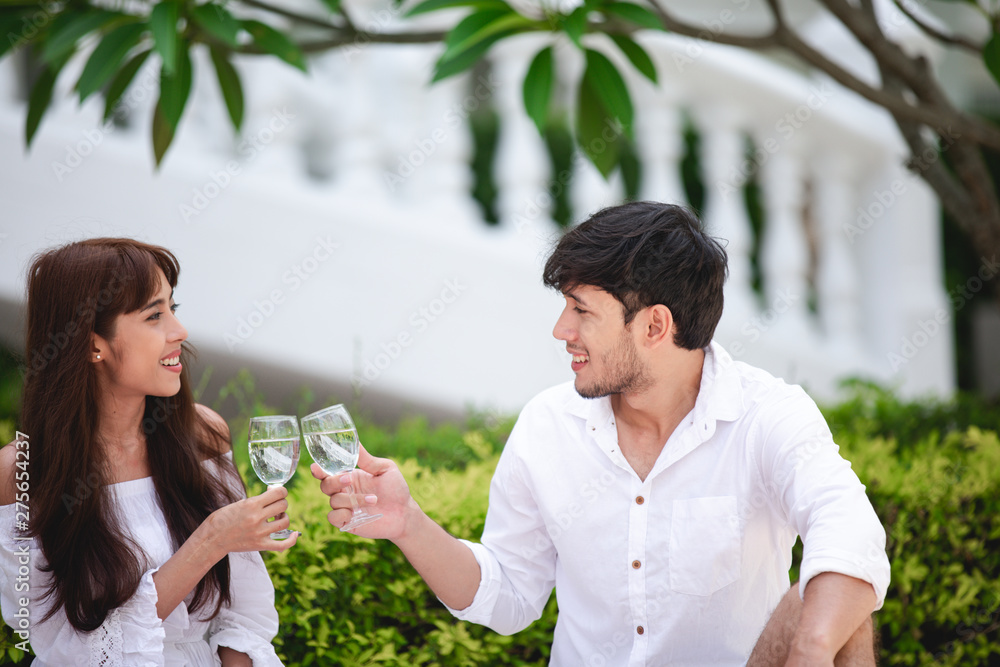 Fototapeta premium Happy Romantic Couples lover talking and drinking wine while having a picnic at home