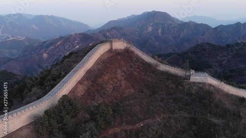 Great Wall of China at evening twilight, aerial shot at Badaling site. Tower topping hill, embattled structure follow slopes on right and left. Highland area of Yanqing District photo