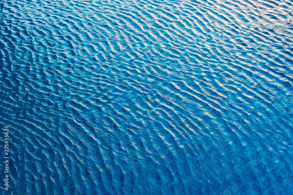Abstract background from water wave in pool with sunlight. Travel and summer background concept. Blue backdrop. Abstract background from water wave in pool with sunlight. Travel and summer background concept. Blue backdrop.