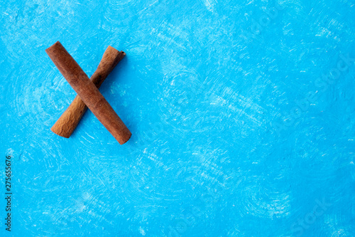 x from cinnamon sticks, innamon sticks on wood table with bundles of cinnamon in soft focus in background. photo