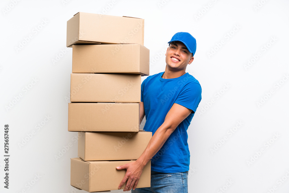 Delivery man over isolated white wall with lots of boxes Delivery man over isolated white wall with lots of boxes