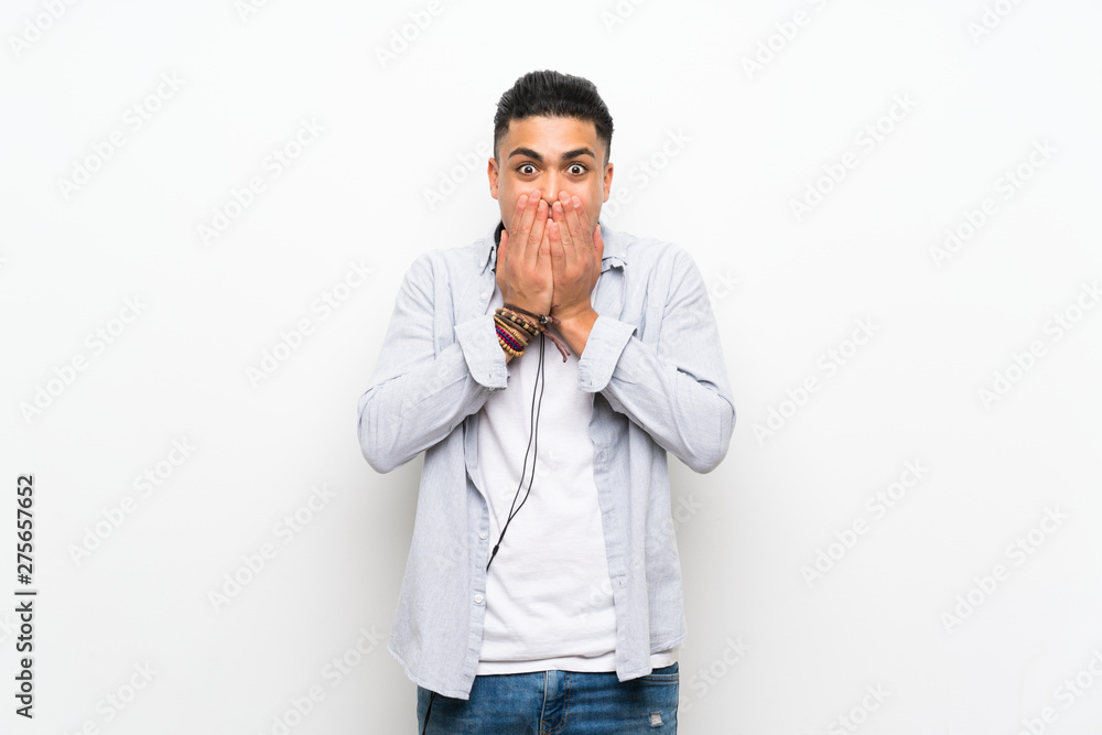 Young man over isolated white wall with earphones with surprise facial expression Young man over isolated white wall with earphones with surprise facial expression
