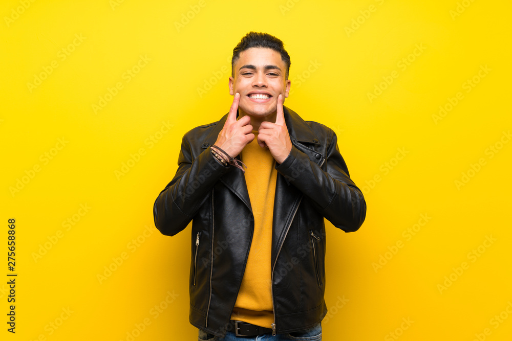 Young man over isolated yellow background smiling with a happy and pleasant expression Young man over isolated yellow background smiling with a happy and pleasant expression