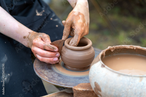 Potter's hands making clay pot.