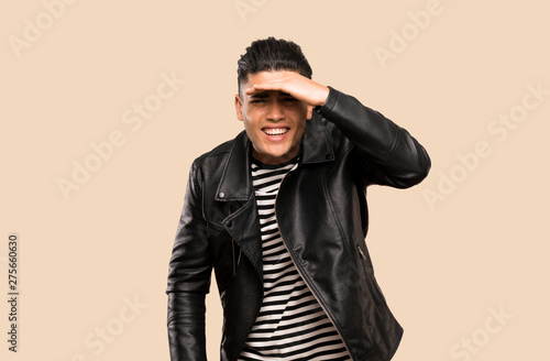 Young man looking far away with hand to look something over isolated background