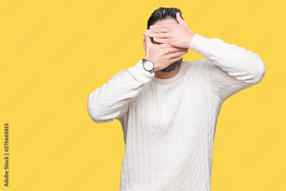 Young handsome man wearing glasses over isolated background Covering eyes and mouth with hands, surprised and shocked. Hiding emotion Young handsome man wearing glasses over isolated background Covering eyes and mouth with hands, surprised and shocked. Hiding emotion