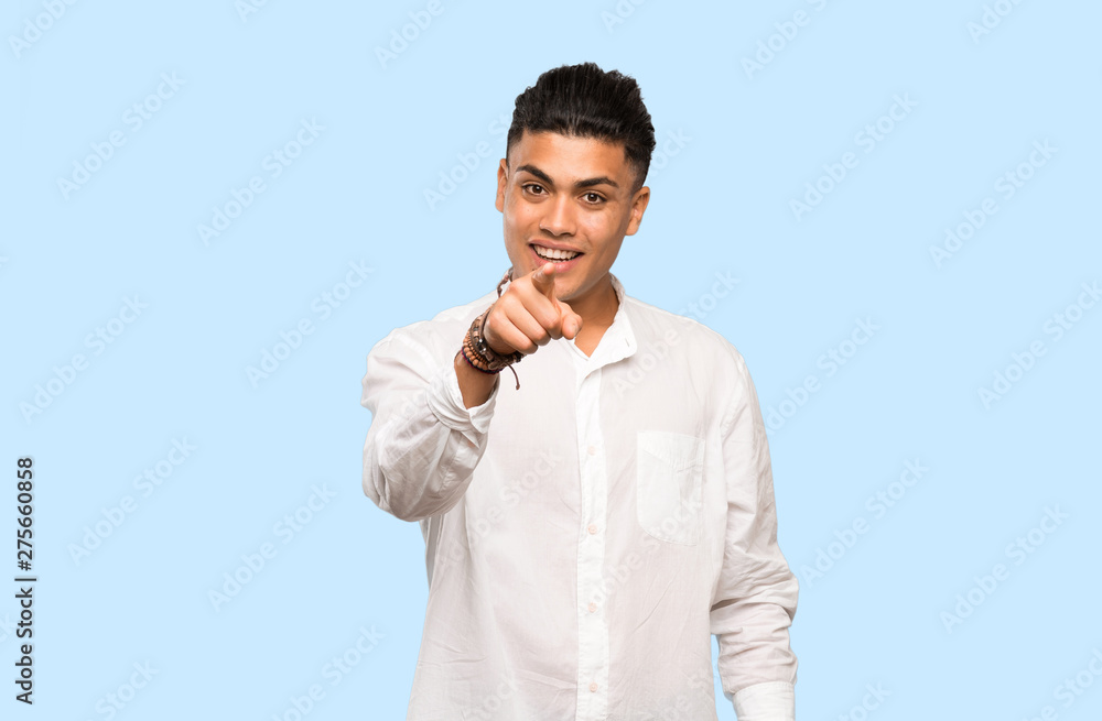 Young man surprised and pointing front on colorful background Young man surprised and pointing front on colorful background