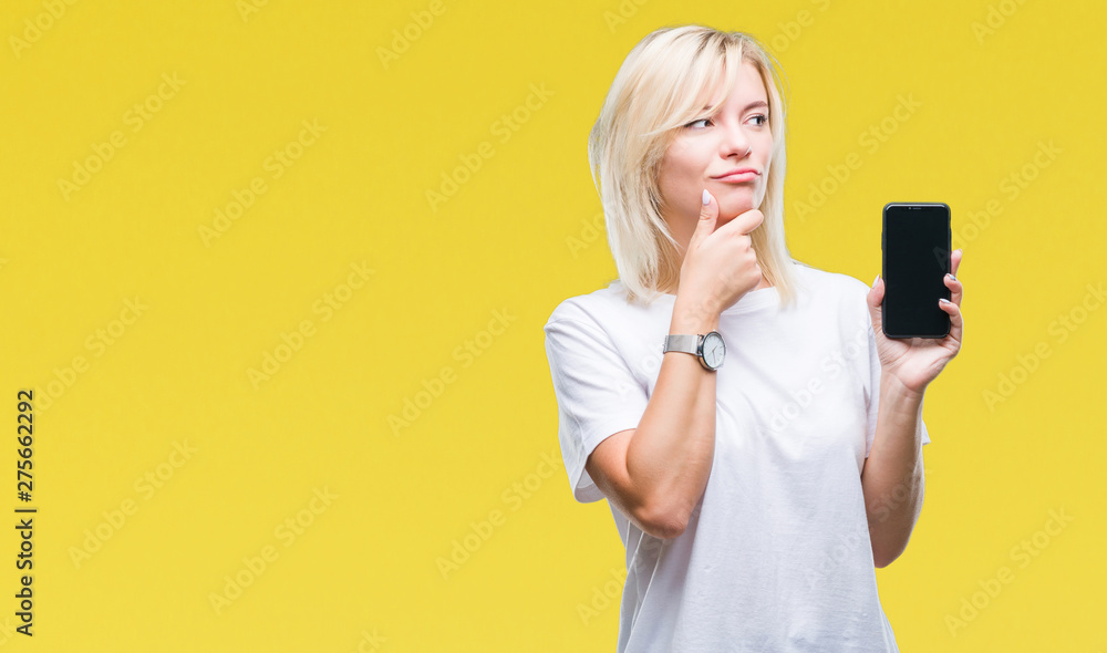 Young beautiful blonde woman showing screen of smartphone over isolated background serious face thinking about question, very confused idea Young beautiful blonde woman showing screen of smartphone over isolated background serious face thinking about question, very confused idea