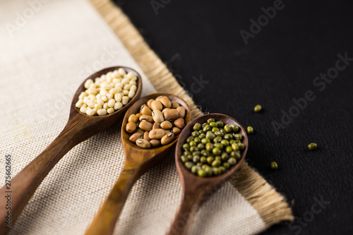 collection set of urad dal, beans, green peas, lentils, rice in wooden spoons.