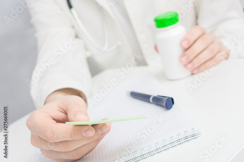 Therapist wrote a prescription  holds in hand a medicine  close up  medically concept