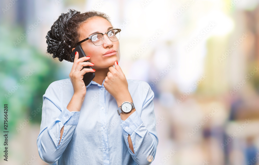 Young braided hair african american business girl showing calling using smartphone over isolated background serious face thinking about question, very confused idea