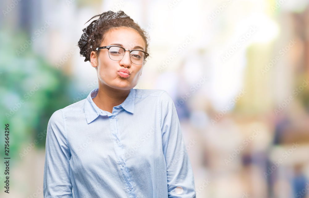 Young braided hair african american business girl wearing glasses over isolated background puffing cheeks with funny face. Mouth inflated with air, crazy expression. Young braided hair african american business girl wearing glasses over isolated background puffing cheeks with funny face. Mouth inflated with air, crazy expression.