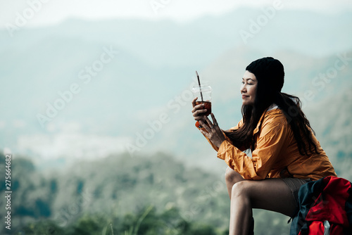 Hiker asian woman sitting and drinking coffee for relax and rest on mountain. Female adventure backpack and trips camping on hike in outdoor nature. Travel and vacations Concept
