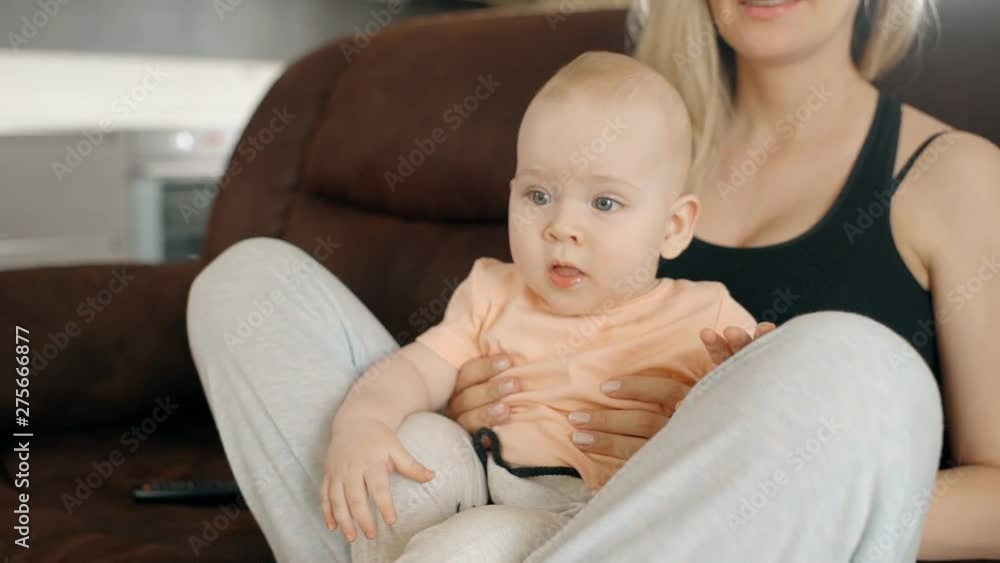 Young mother with little baby are sitting on sofa in home interior. Young mother with little baby are sitting on sofa in home interior.