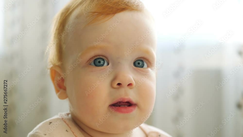 Redhead baby girl playing with book turning pages Redhead baby girl playing with book turning pages