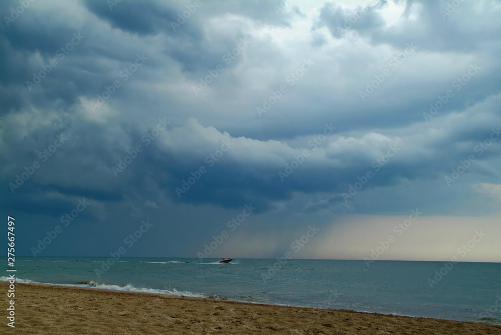 storm clouds over the sea before a hurricane. motor boat in the sea against the backdrop of thunder clouds