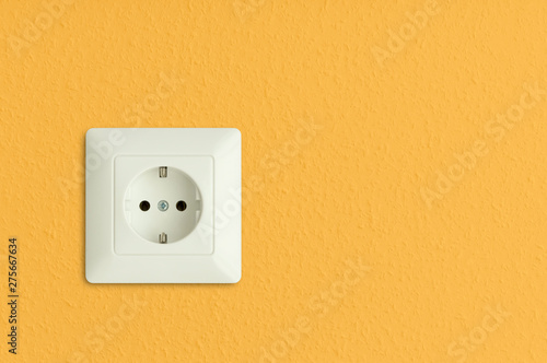 electrical socket on sunny yellow wall, solar power, electric power outlet, european standard