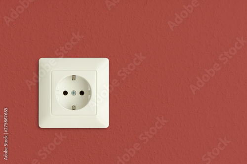  electrical power socket on red wall, closeup, european standard, electric power outlet