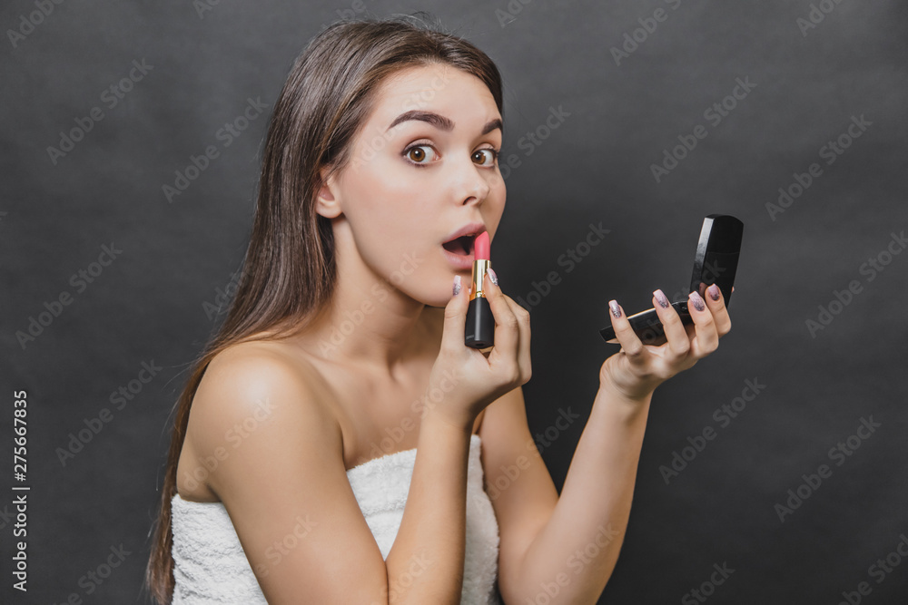 Pretty beautiful girl paints her lips with red lipstick. Skin care concept. Pretty beautiful girl paints her lips with red lipstick. Skin care concept.