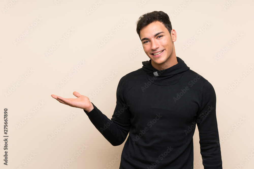 Handsome man over isolated background holding copyspace imaginary on the palm Handsome man over isolated background holding copyspace imaginary on the palm