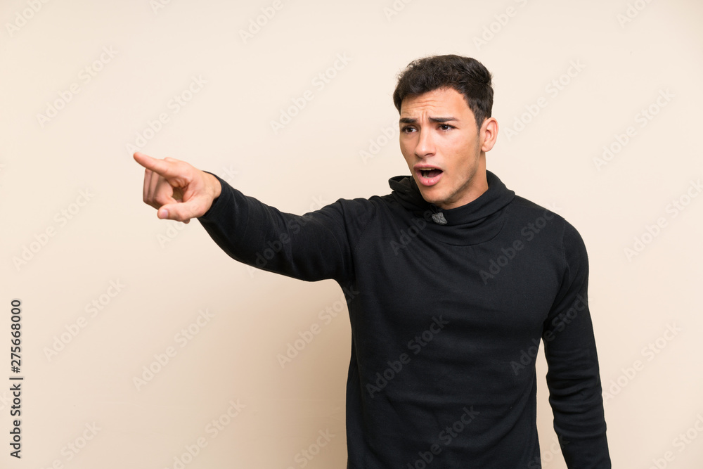 Handsome man over isolated background pointing away Handsome man over isolated background pointing away