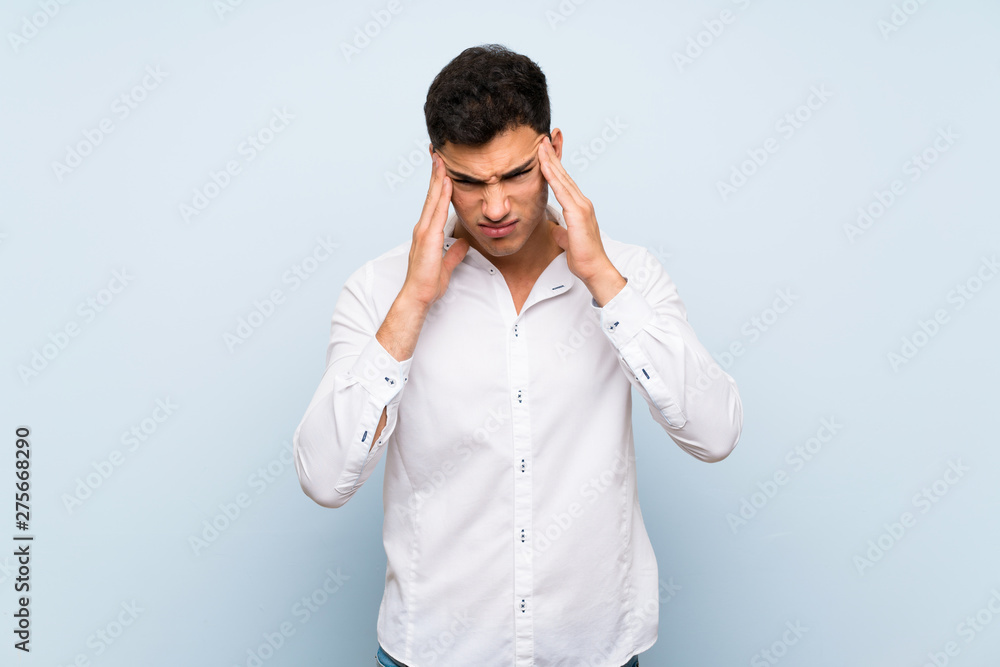 Handsome man over blue wall with headache Handsome man over blue wall with headache