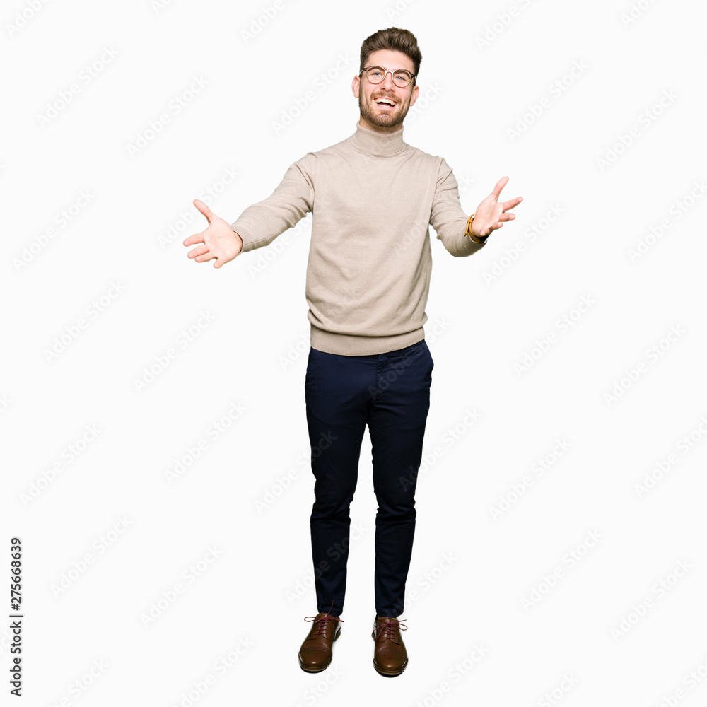 Young handsome business man wearing glasses looking at the camera smiling with open arms for hug. Cheerful expression embracing happiness. Young handsome business man wearing glasses looking at the camera smiling with open arms for hug. Cheerful expression embracing happiness.