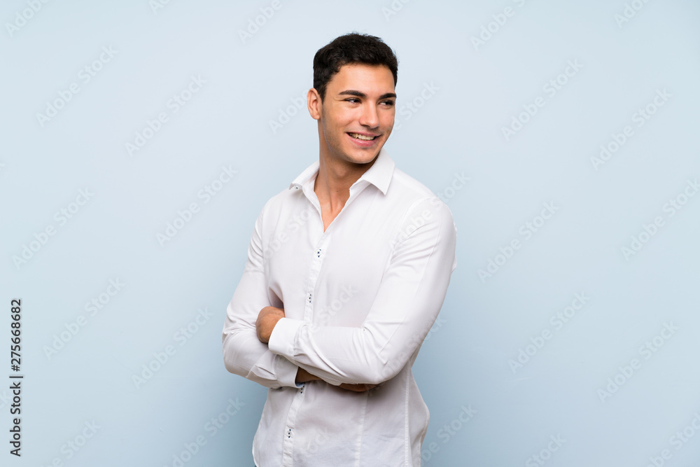 Handsome man over blue wall with arms crossed and happy Handsome man over blue wall with arms crossed and happy
