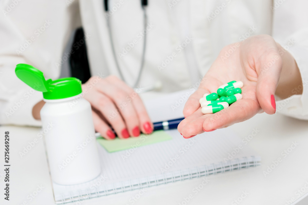 Doctor holds a handful of capsules in his hand, container of medicine, close up, background, copy space, advertising, text